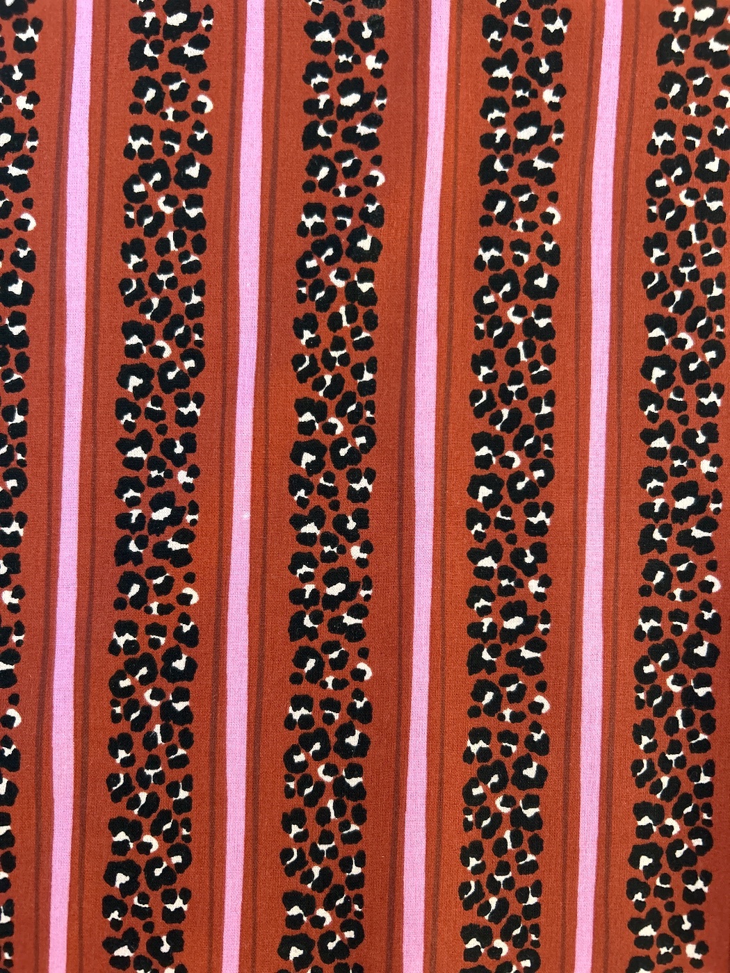 Animal print con rayas rosas. Fondo color teja.